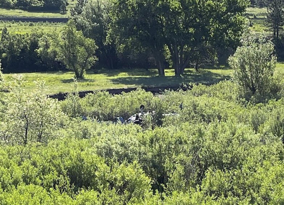 In this photo provided by Douglas County Sheriff's Office posted on X, multiple agencies respond to a small plane crash in a field just east of I-25, around the Larkspur, Colo., exit, Sunday, June 16, 2024. The Douglas County Sheriff's Office says the plane apparently hit a sign on the highway, causing it to veer off to the east before crashing. (Douglas County Sheriff's Office via AP)