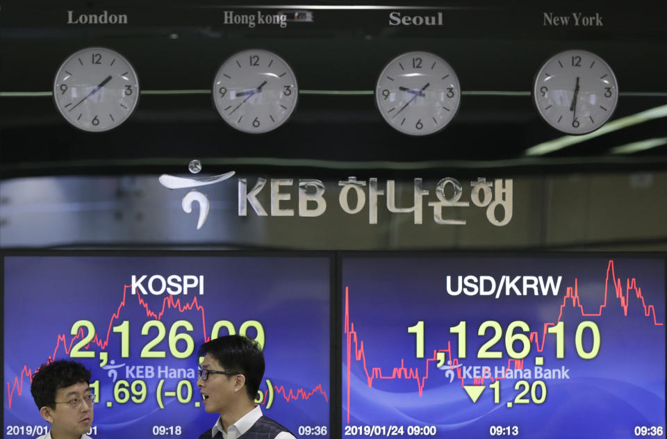 Currency traders talk near the screens showing the Korea Composite Stock Price Index (KOSPI), left, and the foreign exchange rate between U.S. dollar and South Korean won at the foreign exchange dealing room in Seoul, South Korea, Thursday, Jan. 24, 2019. Asian stocks were mostly higher on Thursday as positive U.S. earnings reports reassured investors that the world’s largest economy was on track. (AP Photo/Lee Jin-man)