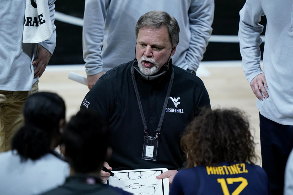 West Virginia head coach Mike Carey talks to his players during the first half of an of an NCAA college basketball game against Baylor in the final round of the Big 12 Conference tournament in Kansas City, Mo, Sunday, March 14, 2021. (AP Photo/Charlie Riedel)