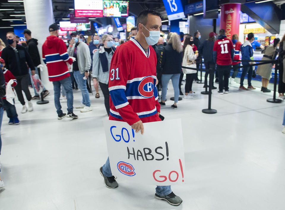 Montreal Canadiens fans walk through the concourse ahead of the team's home-opener NHL hockey game against the New York Rangers in Montreal, Saturday, Oct. 16, 2021. (Graham Hughes/The Canadian Press via AP)