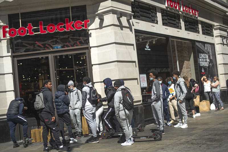 Customers queue to enter Foot Locker in Oxford Street, London as non-essential shops in England open.