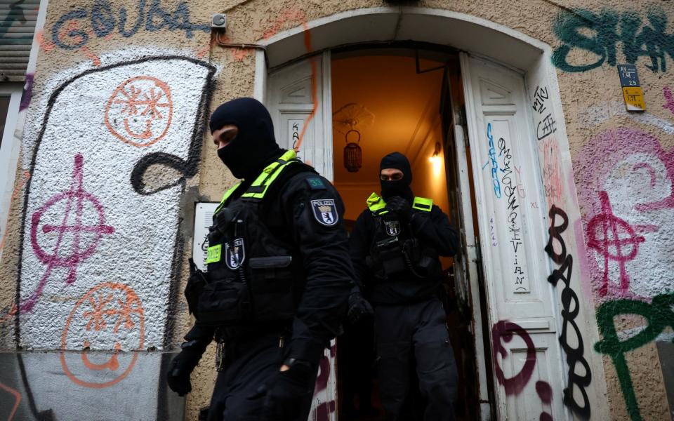 German police officers leave a house during a raid against people supporting the Palestinian Islamist group Hamas