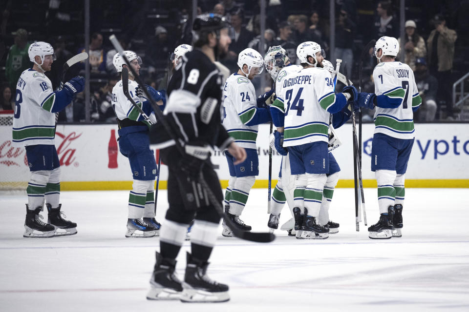 Vancouver Canucks celebrate an overtime win against the Los Angeles Kings in an NHL hockey game Tuesday, March 5, 2024, in Los Angeles. (AP Photo/Kyusung Gong)