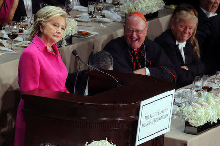 U.S. presidential nominee Hillary Clinton delivers remarks as Republican U.S. presidential nominee Donald Trump smiles (R) during the Alfred E. Smith Memorial Foundation dinner in New York, U.S. October 20, 2016. REUTERS/Carlos Barria