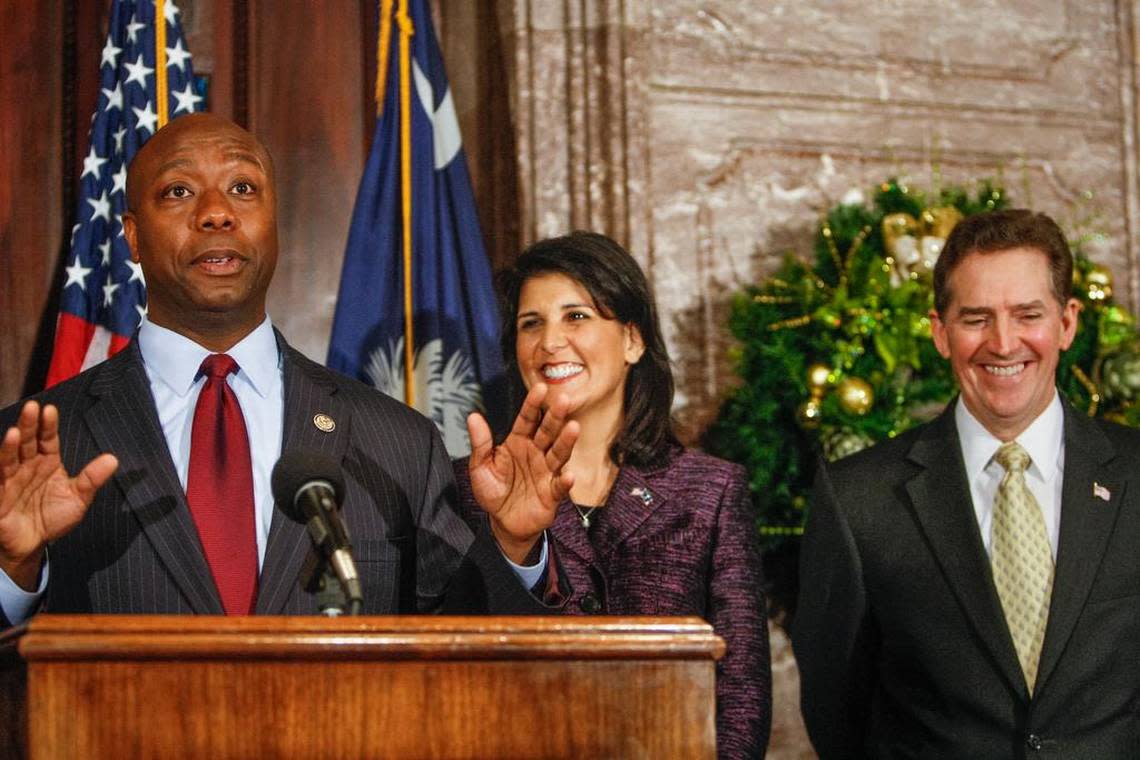 U.S. Rep. Tim Scott speaks Monday to reporters at the South Carolina Statehouse after being officially introduced by Gov. Nikki Haley to fill the vacant U.S.. Senate seat vacated by departing U. S. Sen. Jim DeMint, far right.