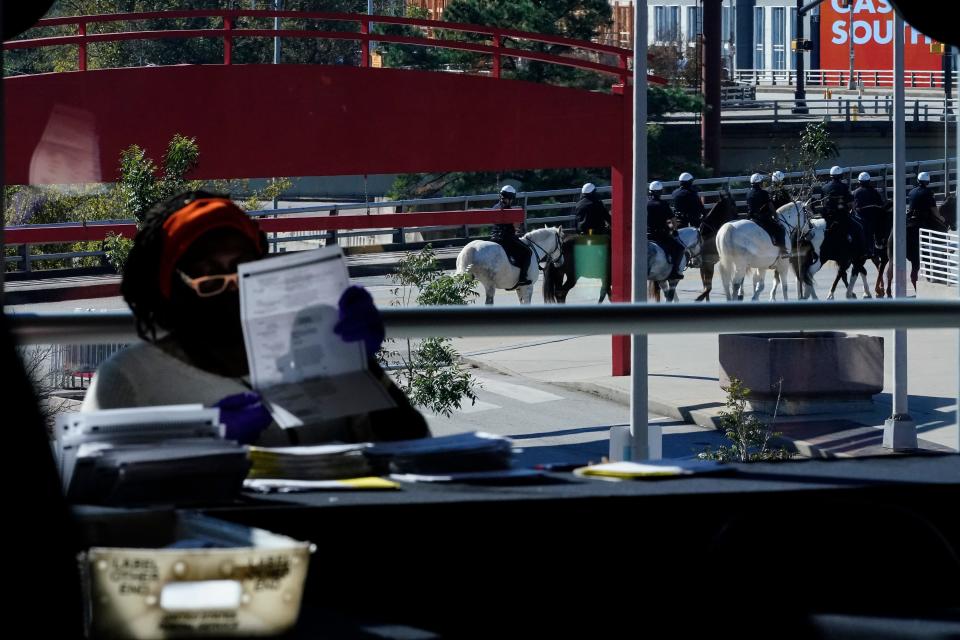 Police on horsebacks gather outside as election personnel examine a ballot as vote counting in the general election continues at State Farm Arena, Wednesday, Nov. 4, 2020, in Atlanta.