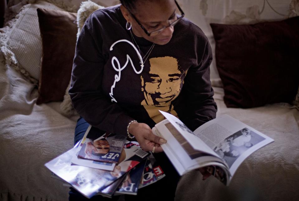 This Jan. 2, 2013, photo, shows Victoria Wimberley, who will be attending President Barack Obama's inauguration for the second time, looking over some of the memorabilia in her home in Decatur, Ga. Four years and one re-election after his historic oath-taking as America's first black president, some of the thrill for Barack Obama is gone. Wimberley brought four busloads of people to Washington for the 2009 inauguration. She's coming again this month, though with two fewer buses, which she blamed on the high price for accommodations, not any lack of excitement for Obama. (AP Photo/David Goldman)