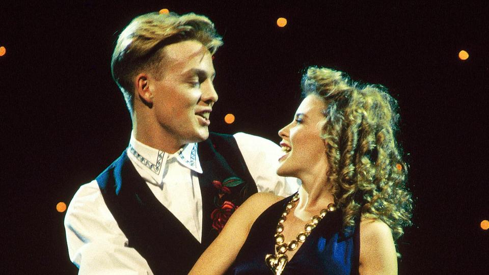 Jason Donovan and Kylie Minogue singing and dancing