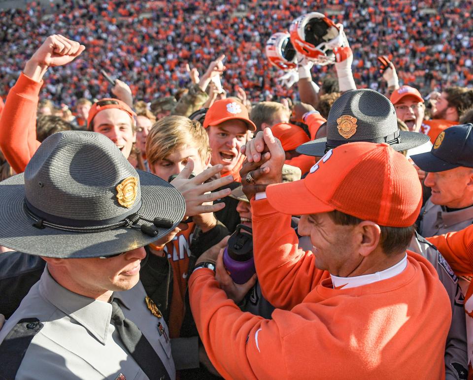 Clemson coach Dabo Swinney is swarmed by students last week after the Tigers beat Wake Forest to stay alive for a spot in the ACC championship game.