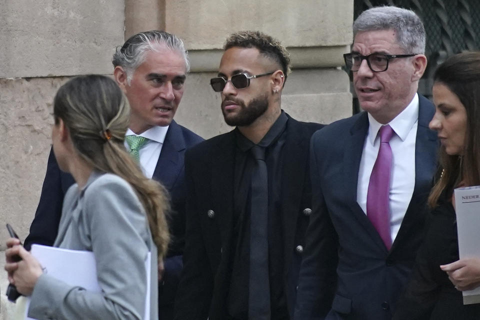 Former FC Barcelona player Neymar who now plays for Paris Saint-Germain, centre, arrives at a court in Barcelona, Spain, Monday Oct. 17, 2022. Neymar returned to Spain Monday to face trial on fraud charges regarding his 2013 transfer from Santos to FC Barcelona. The Brazilian forward, his father, and the former executives of Barcelona and Santos are accused of hiding the true cost of his transfer with the alleged goal of cheating a private Brazilian company.(AP Photo/Joan Mateu Parra)