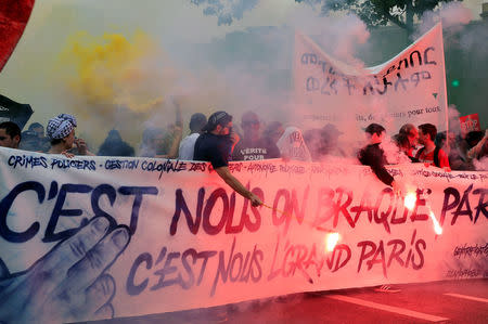 Protesters walk behind a banner which reads, "We're held up - The greater Paris" during a demonstration by French unions and the France Insoumise" (France Unbowed) political party to protest against government reforms, in Paris, France, May 26, 2018. REUTERS/Gonzalo Fuentes