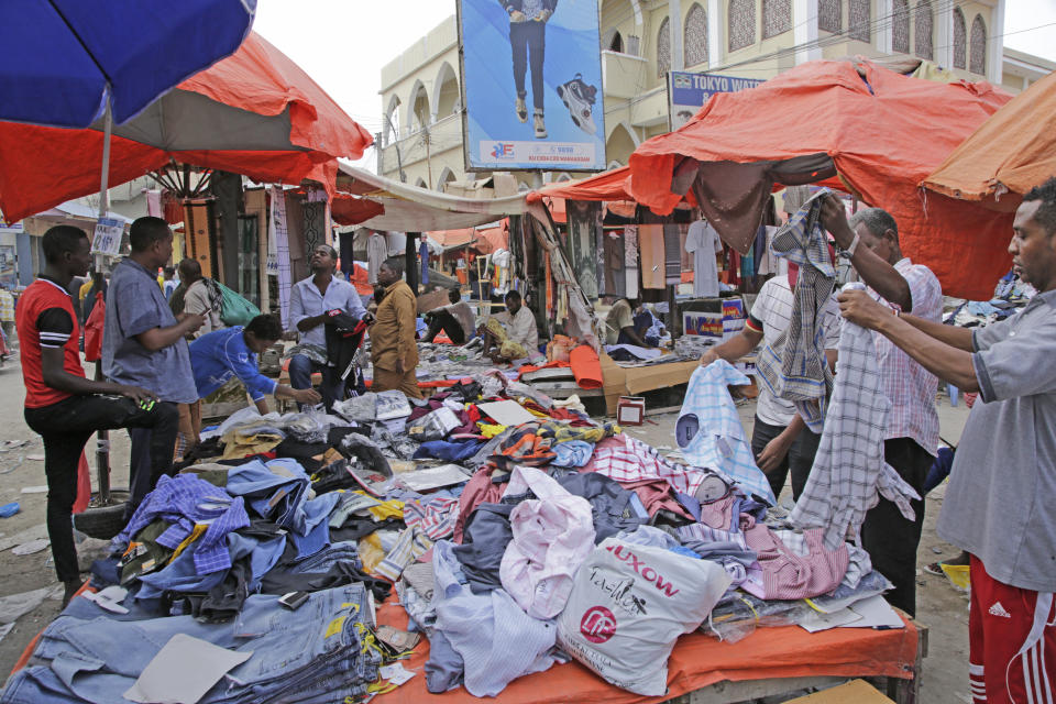 People shop at a street market as preparations are made for the Muslim holiday of Eid al-Fitr, next Friday, which marks the end of the holy fasting month of Ramadan, in Mogadishu, Somalia, Wednesday, April 19, 2023,. (AP Photo/Farah Abdi Warsameh)