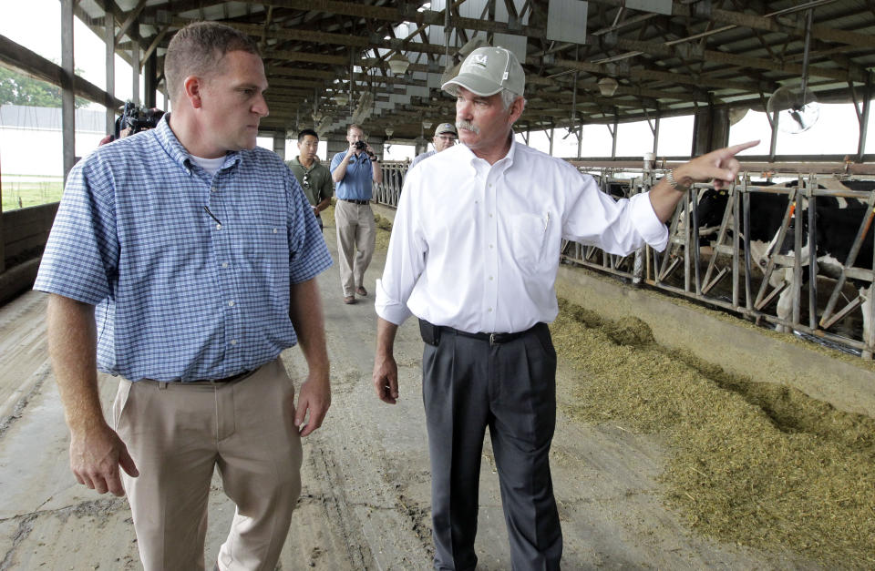 Joe Kelsay, left, directory of the Indiana State Department of Agriculture, shows USDA Farm and Foreign Agricultural Services Undersecretary Michael Scuse around his family's dairy operation in Whiteland, Ind., Thursday, July 19, 2012. Scuse mets with local farmers and toured drought disaster areas in Indiana. (AP Photo/Michael Conroy)