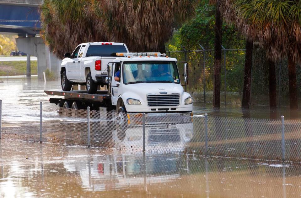 A tow truck drives through the flooded road cause by heavy rains at West Perimeter Road in the Fort Lauderdale on Thursday, April 13, 2023.