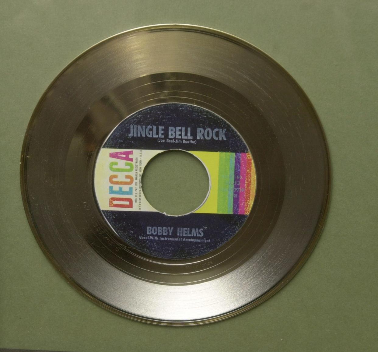 A commemorative Decca record honors the sale of 10 million copies of "Jingle Bell Rock" by Bobby Helms.