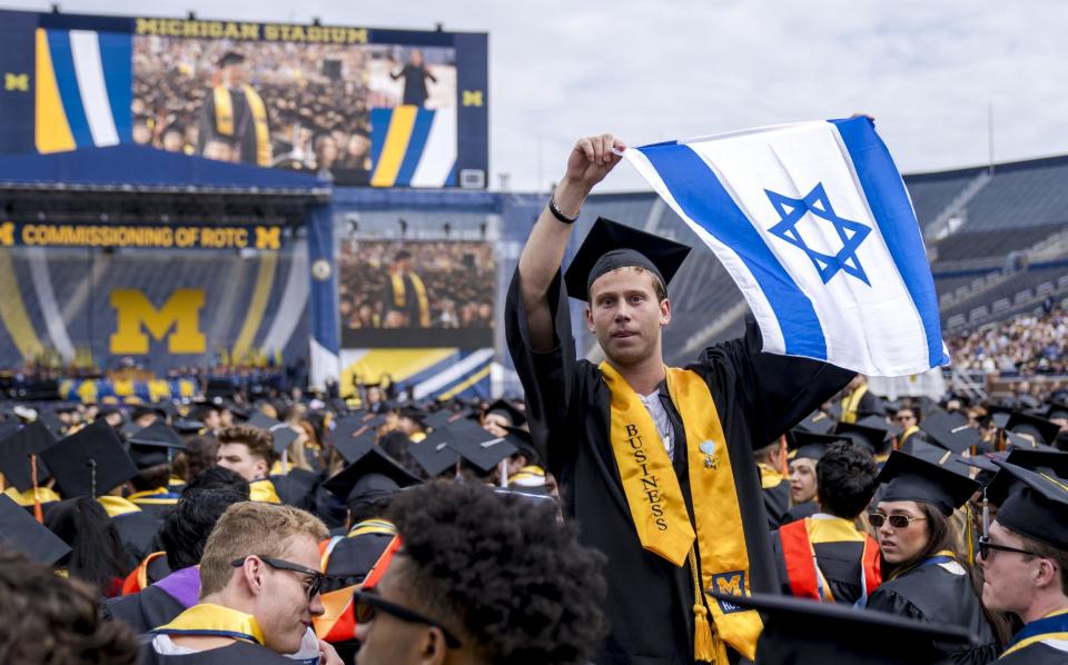A student holds an Israeli flag during the University of Michigan's graduation ceremony