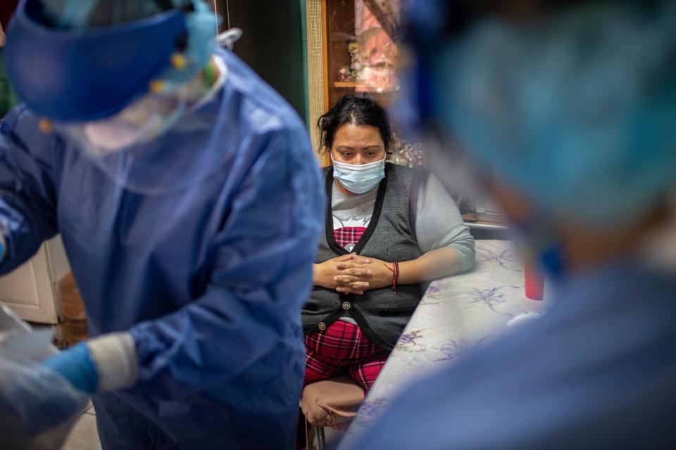 Una mujer mexicana espera ser examinada por trabajadores de la salud durante una visita puerta a puerta para llevar a cabo las pruebas COVID-19 en la Ciudad de México. Foto: Pedro Pardo / AFP vía Getty Images.