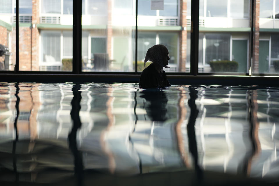 An Amish woman from Ohio is silhouetted as she swims among Tesla BioHealing generators at Tesla BioHealing's Tesla Wellness Hotel and MedBed Center on Wednesday, Nov. 15, 2023, in Butler, Pa. She visits the center twice a month. (AP Photo/Carolyn Kaster)