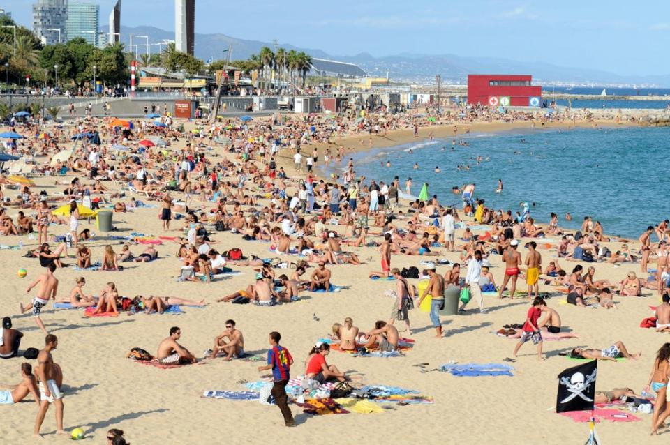 Holidaymakers on Platja Nova Icarie beach in Barcelona (PA Archive)