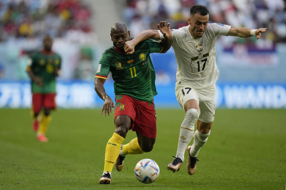 Cameroon's Christian Bassogog, left, fights for the ball with Serbia's Filip Kostic during the World Cup group G soccer match between Cameroon and Serbia, at the Al Janoub Stadium in Al Wakrah, Qatar, Monday, Nov. 28, 2022. (AP Photo/Francisco Seco)