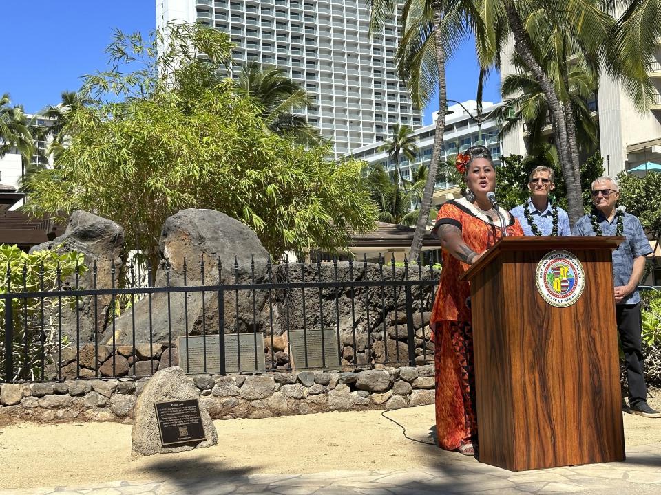 Hinaleimoana Wong-Kalu speaks in Honolulu on Tuesday, Oct. 24, 2023 during a ceremony blessing a new plaque for the Kapaemahu stones monument in Waikiki. Honolulu officials introduced a new interpretive plaque for four large boulders in the center of Waikiki that honor Taihitian healers of dual male and female spirit who visited Oahu some 500 years ago. (AP Photo/Audrey McAvoy)