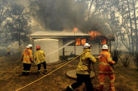 Firefighters battle the Morton Fire as it burns a home near Bundanoon, New South Wales, Australia, on Thursday, Jan. 23, 2020. (AP Photo/Noah Berger)