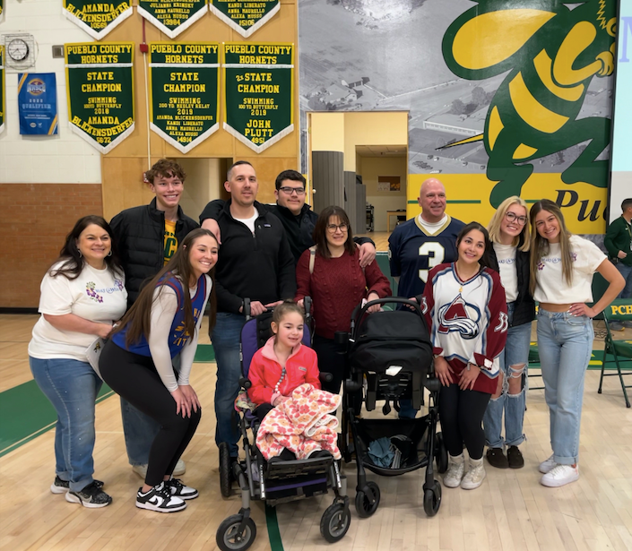 Pueblo County High School students and staff pose with 6-year-old Poppy Pino and her family during the kick-off of Wish Week 2024.