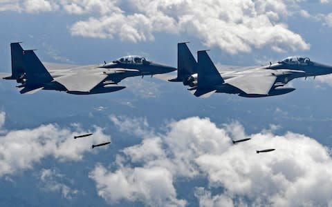 South Korean F-15K fighter jets drop bombs at a shooting range in Gangwon Province, east of Seoul - Credit: AFP