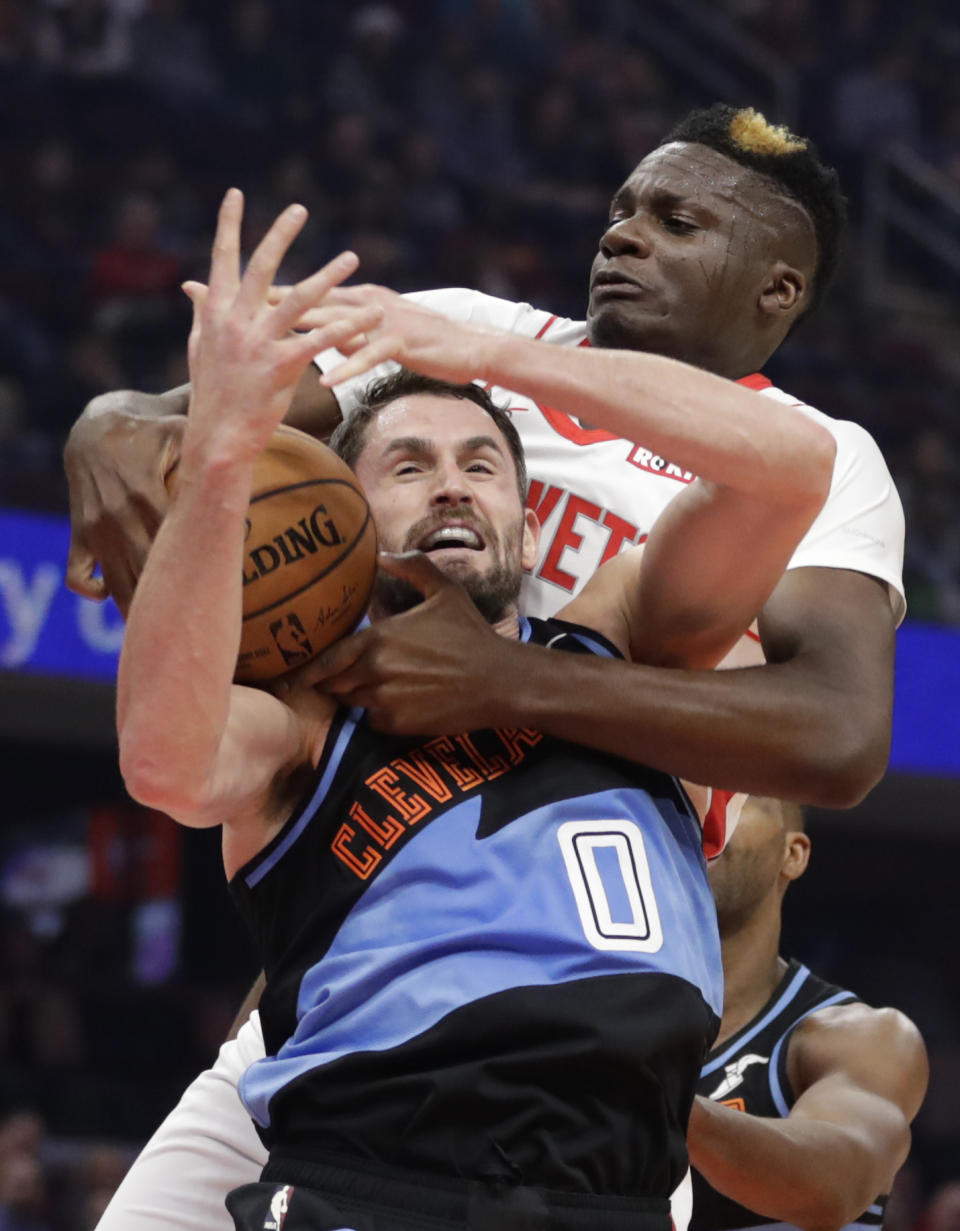 Houston Rockets' Clint Capela, back, and Cleveland Cavaliers' Kevin Love battle for a loose ball in the first half of an NBA basketball game, Wednesday, Dec. 11, 2019, in Cleveland. (AP Photo/Tony Dejak)