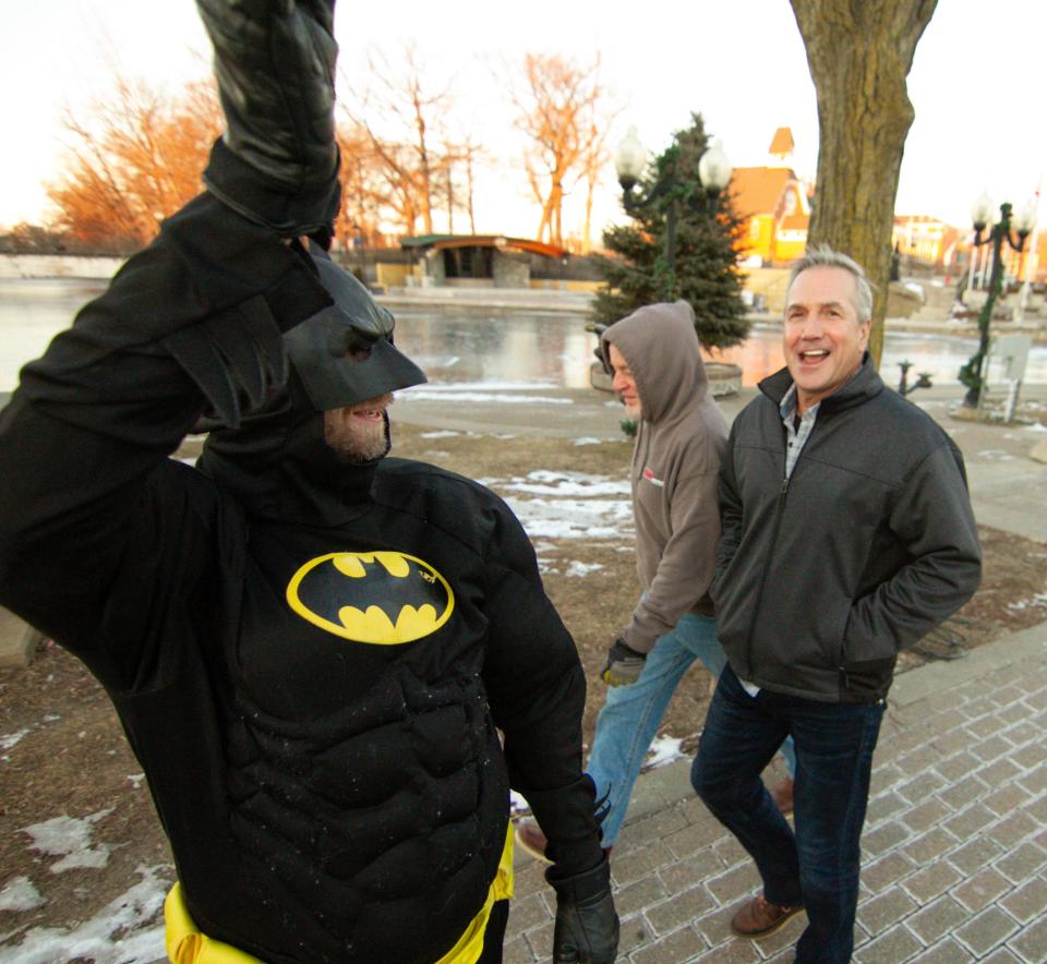 Batman greets passers-by near Brighton's Mill Pond, telling them to "Stay warm and stay safe" Friday, Jan. 21, 2022.