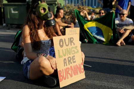 Climate activists attend a protest outside Brazil's embassy due to the wildfires at Amazon rainforest, in Nicosia