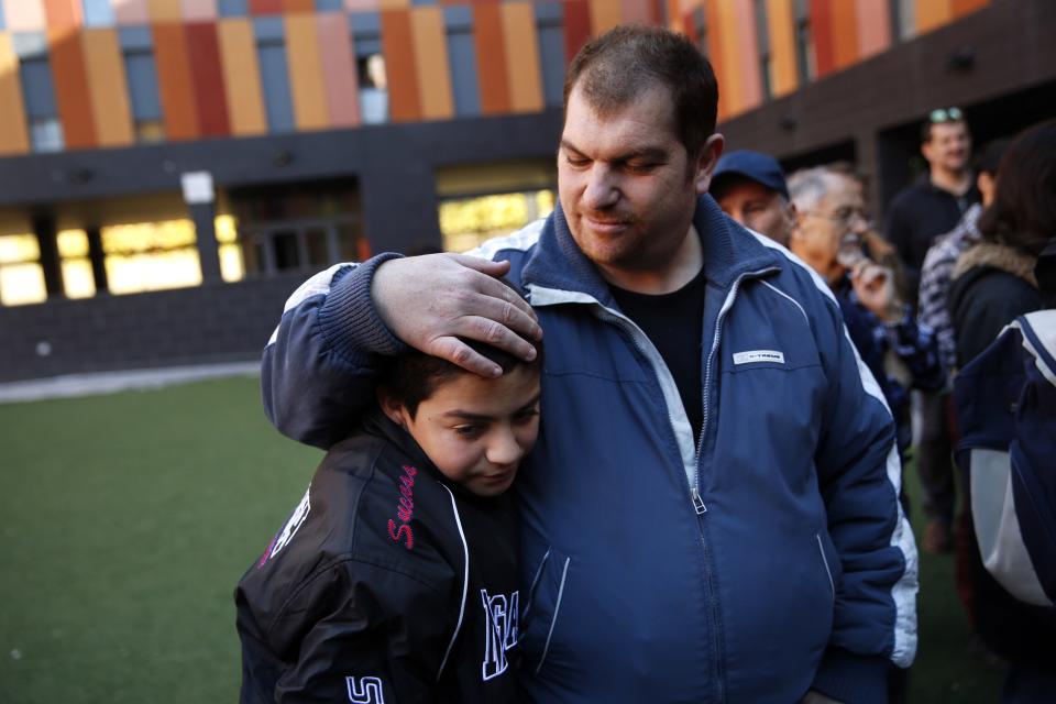 Giraldo Zacarias embraces his son Christopher after learning that their eviction had been temporarily suspended in Madrid