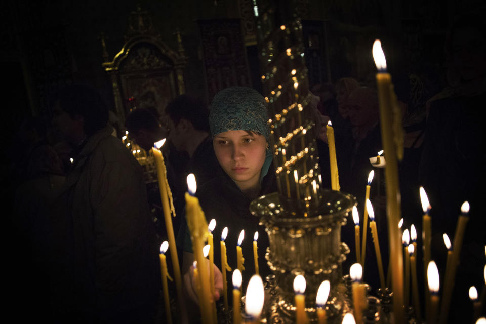 A Ukrainian Orthodox devotee cleans a candelabrum within a church during Easter Sunday rites in Donetsk, Ukraine, early Sunday, April 20, 2014. (AP Photo/Manu Brabo)