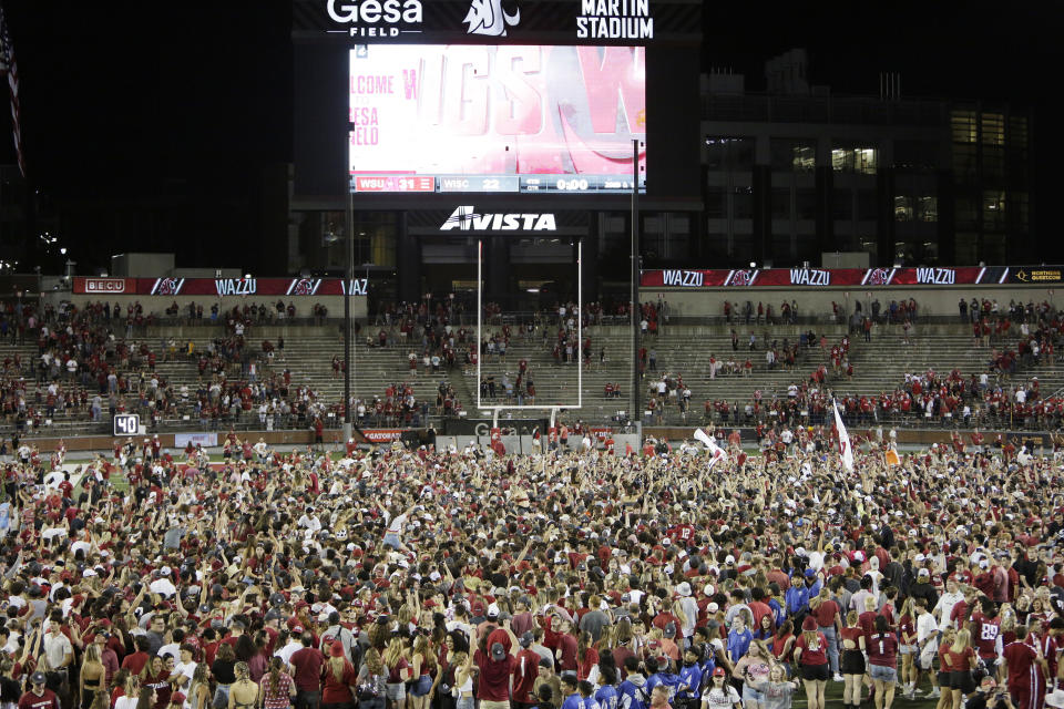 Washington State fans celebrate on the field after team's win over Wisconsin in an NCAA college football game, Saturday, Sept. 9, 2023, in Pullman, Wash. (AP Photo/Young Kwak)