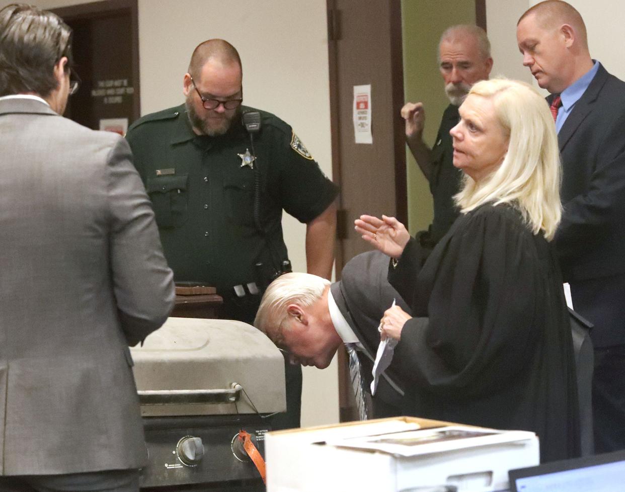 Attorneys and Judge Elizabeth Blackburn look at the BBQ grill Friday, June 2, 2023, that Robert Remus Jr. is accused of using to weigh down his father's body in the St. Johns River after killing him in 2012. Remus Jr. is on trial for his father's death.