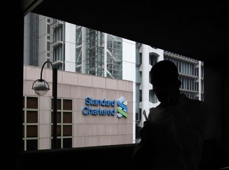 A man walks on a footbridge connected to the Standard Chartered headquarters in Hong Kong August 7, 2012. REUTERS/Bobby Yip