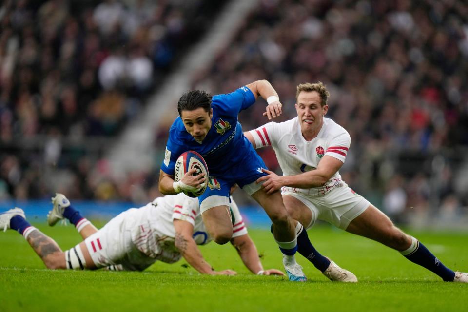 Italy's Ange Capuozzo, centre, tries to avoid being tackled (AP)