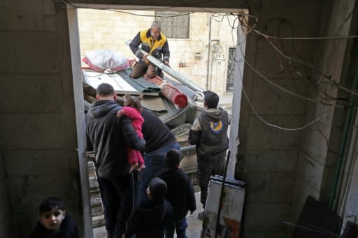 White Helmet rescue volunteers help Abu Ossama pack his belongings into a truck