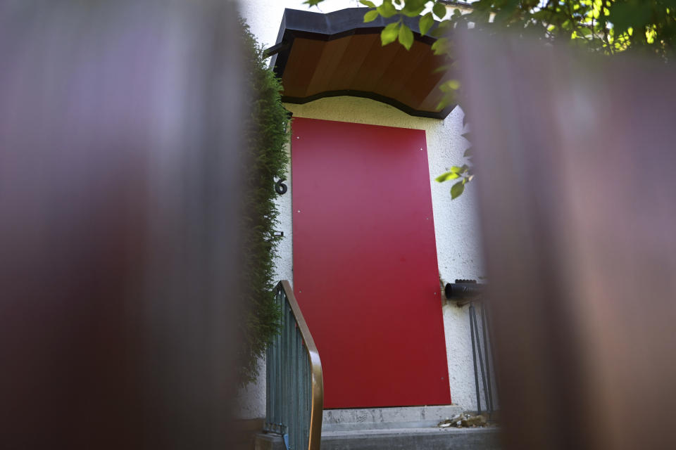 In this picture taken trough a fence the entrance of a house of a suspect in a homicide case is pictured in Kassel, Germany, Tuesday, June 18,2019. Police on Saturday arrested a 45-year-old known far-right extremist with a string of convictions for violent crimes dating back decades. The regional government offical Walter Luebcke, a long-time member of Chancellor Angela Merkel's center-right Christian Democrats, was found shot in the head on June 2 at his home near the central German city of Kassel. (Uwe Zucchi/dpa via AP)