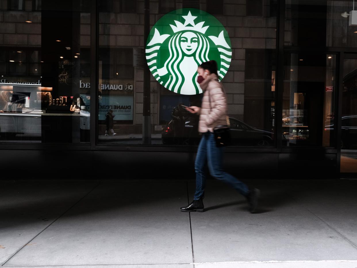 A woman walks by a Starbucks coffee shop in Manhattan on April 04, 2022