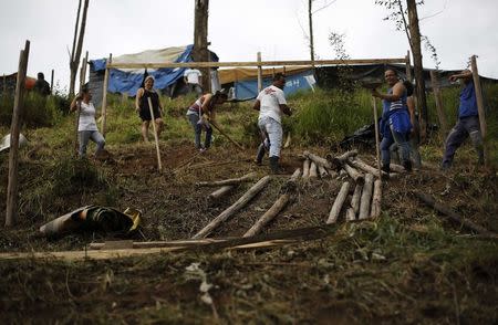 A family of the Brazil's Homeless Workers' Movement (MTST) work on a newly built shack at the "People's World Cup" camp, which houses an estimate of 2,800 families of the movement, in the district of Itaquera near Sao Paulo's World Cup stadium, in Sao Paulo May 7, 2014. REUTERS/Nacho Doce