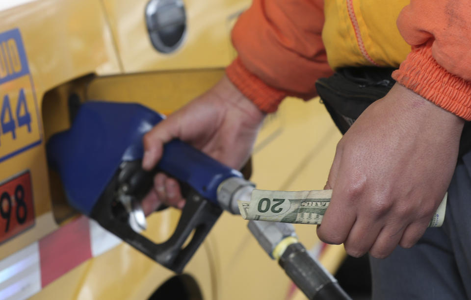 An employee of a gas station fills the fuel tank of a taxi in Quito, Ecuador, Tuesday, Oct. 15, 2019. The recent strike that paralyzed the Andean nation for almost two weeks, has left a gaping hole in Ecuador’s economy, this after President Lenin Moreno called back his elimination of fuel subsidies which provoked the violent protests. (AP Photo/Dolores Ochoa)