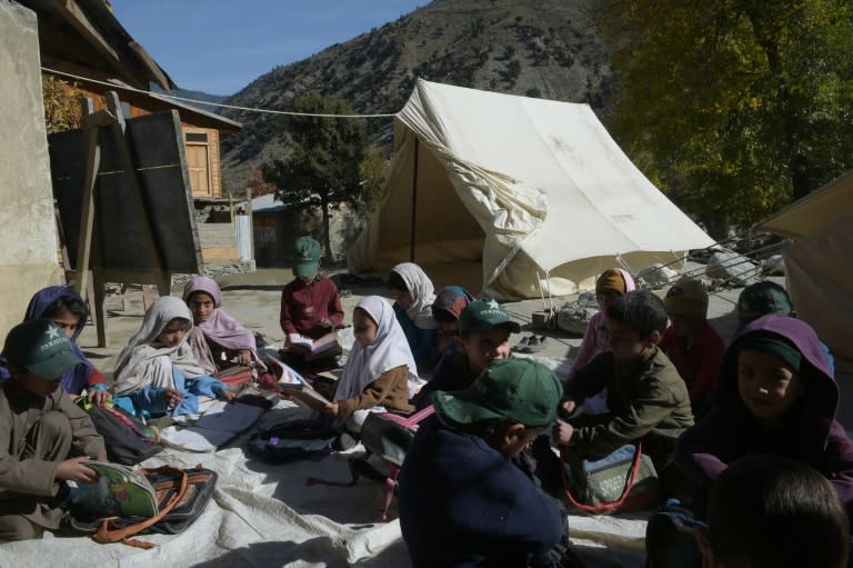 Pakistani children attend class outside an earthquake-damaged school in Brun village of the Bumburate valley