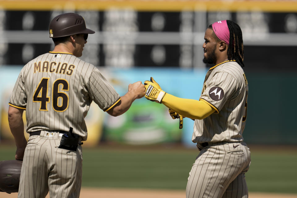 San Diego Padres' Eguy Rosario, right, celebrates with first base coach and outfield instructor David Macias after hitting an RBI single against the Oakland Athletics during the fourth inning of a baseball game Sunday, Sept. 17, 2023, in Oakland, Calif. (AP Photo/Godofredo A. Vásquez)