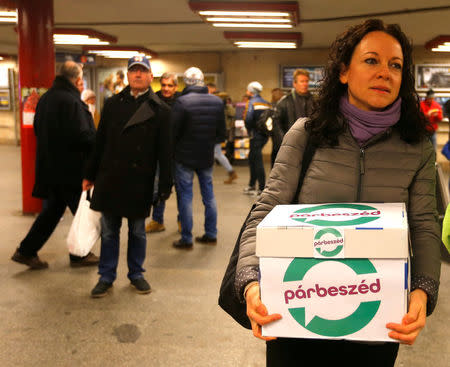 Timea Szabo, co-chair of opposition party Parbeszed Magyarorszagert hands over documents with signatures supporting a referendum on Budapest's 2024 Olympic bid to political movement Momentum at a stand in Budapest, Hungary, February 16, 2017. Picture taken February 16, 2017. REUTERS/Laszlo Balogh