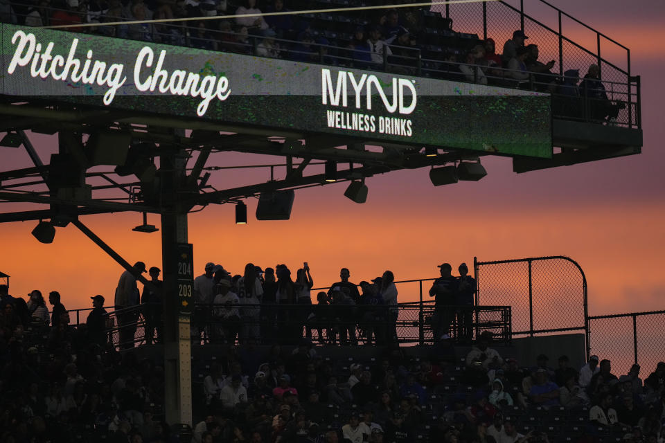 The sun sets behind the bleachers during the seventh inning of a baseball game between the Cincinnati Reds and Chicago Cubs, Saturday, May 27, 2023, in Chicago. (AP Photo/Erin Hooley)