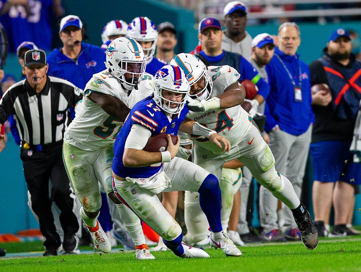 Buffalo Bills quarterback Josh Allen (17), runs by several Dolphins defenders on his way to a first down, during second half action of their NFL football game Jan 07, 2024, in Miami Gardens.