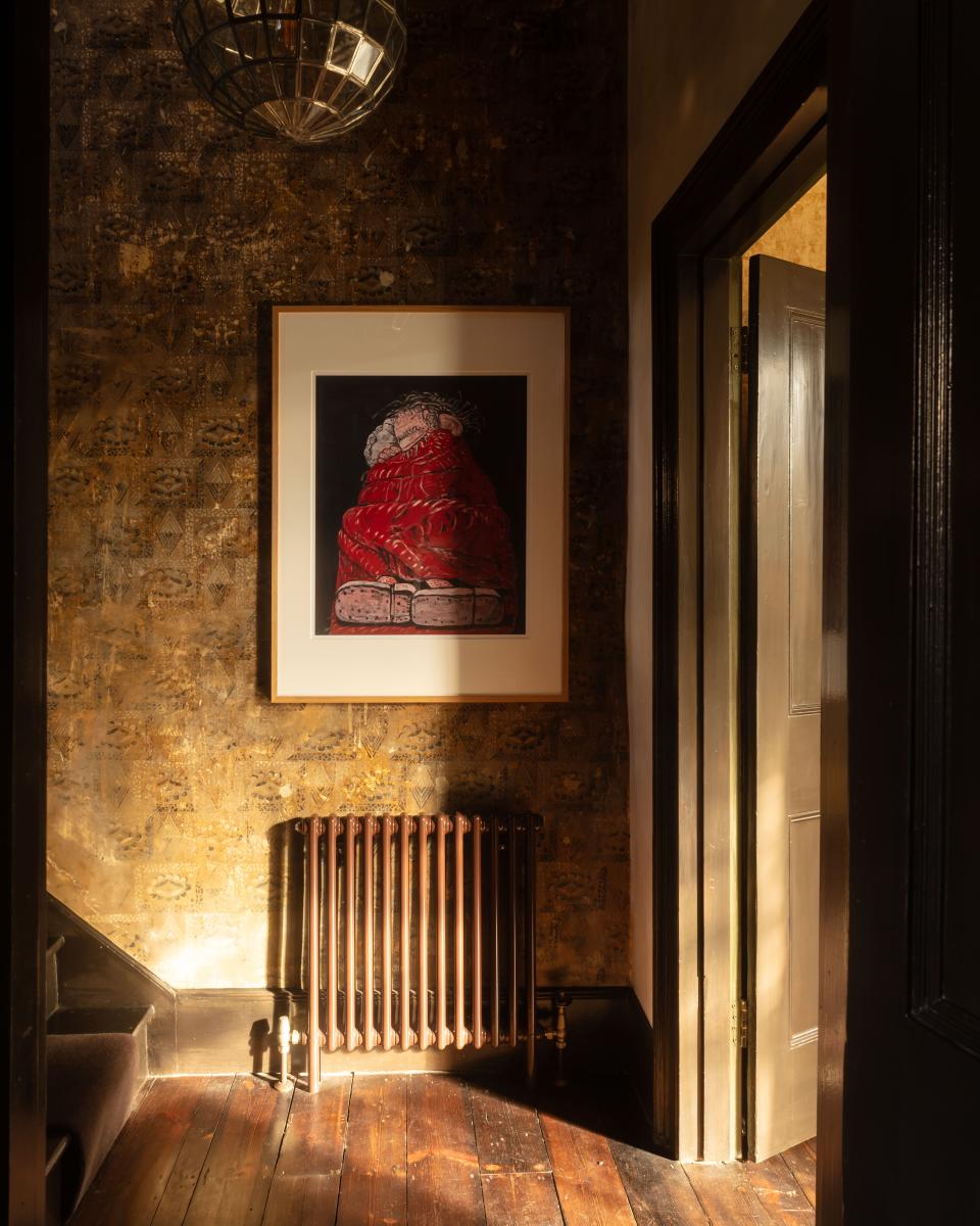 The home’s original wall stenciling, restored by RAG Arts, is visible in the hallway. Adelphi lantern from Jamb, and painting by Philip Guston.