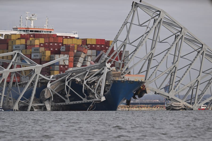 The steel frame of the Francis Scott Key Bridge sits on top of a container ship after the bridge collapsed, Baltimore, Maryland, on March 26, 2024. The bridge collapsed early March 26 after being struck by the Singapore-flagged Dali container ship, sending multiple vehicles and people plunging into the frigid harbor below. There was no immediate confirmation of the cause of the disaster, but Baltimore’s Police Commissioner Richard Worley said there was “no indication” of terrorism. (Photo by Jim WATSON / AFP) (Photo by JIM WATSON/AFP via Getty Images)