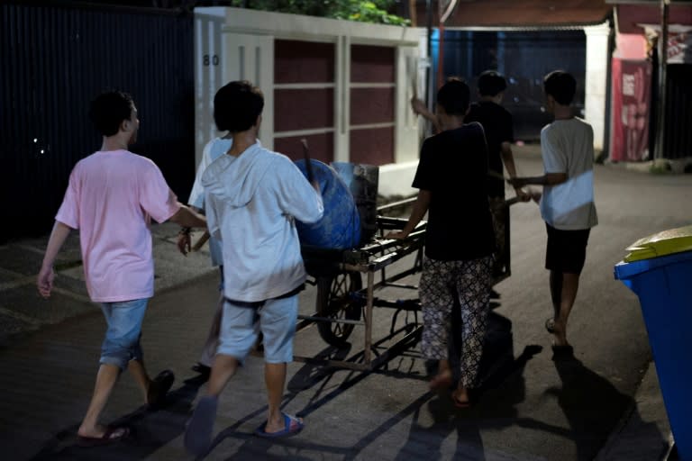 The motley group of children yell and bang on tambourines and drums as they roam the quiet streets of Indonesia's capital